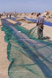 Image du Maroc Professionnelle de  Des ouvriers s'activent à réparer leurs filets de pêches au port de Laayoune, située à quelque kilomètre de la ville de Laayoune capitale du Sahara marocain, Vendredi 21 Septembre 2001. (Photo / Abdeljalil Bounhar)